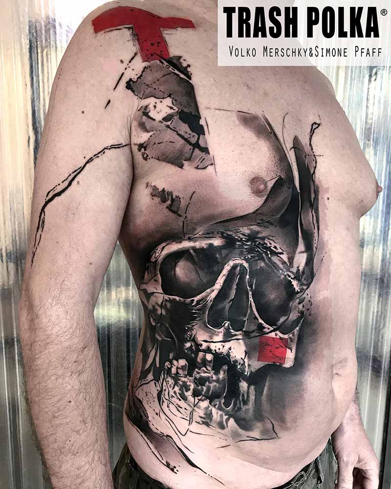 upperbody trash polka tattoo on a man big skull Witz abstract design and a red Cross on the shoulder