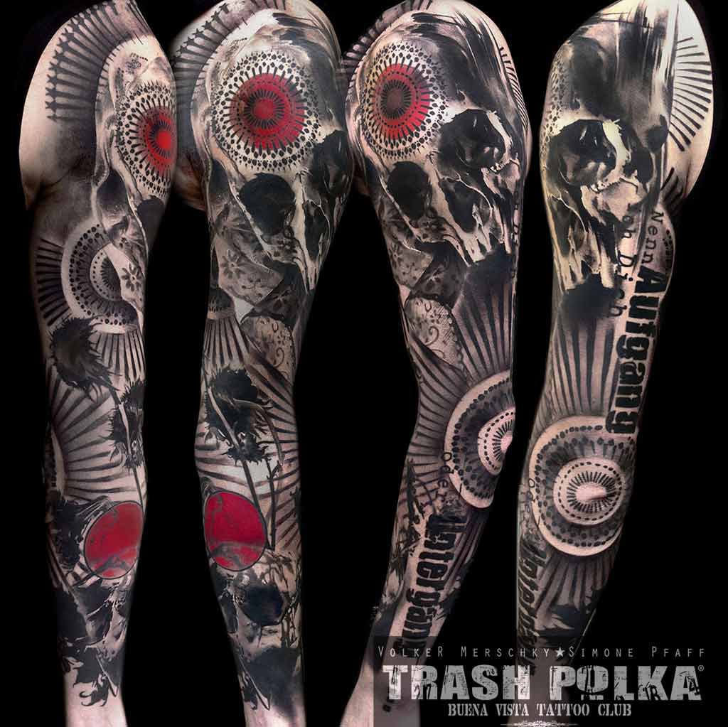 trash polka arm tattoo shows an arm with dead sunflowers and 2 skulls with lace ribbons red accents