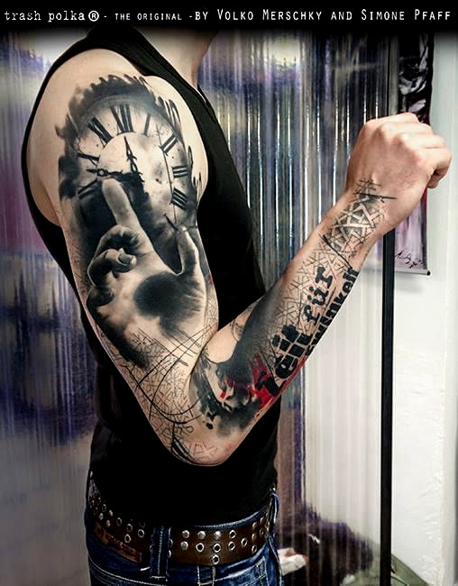 trash polka arm tattoo old clock face of a tower clock on the upper arm in the foreground a hand with the gesture for silence or attention lower arm big letters in german time for eternity